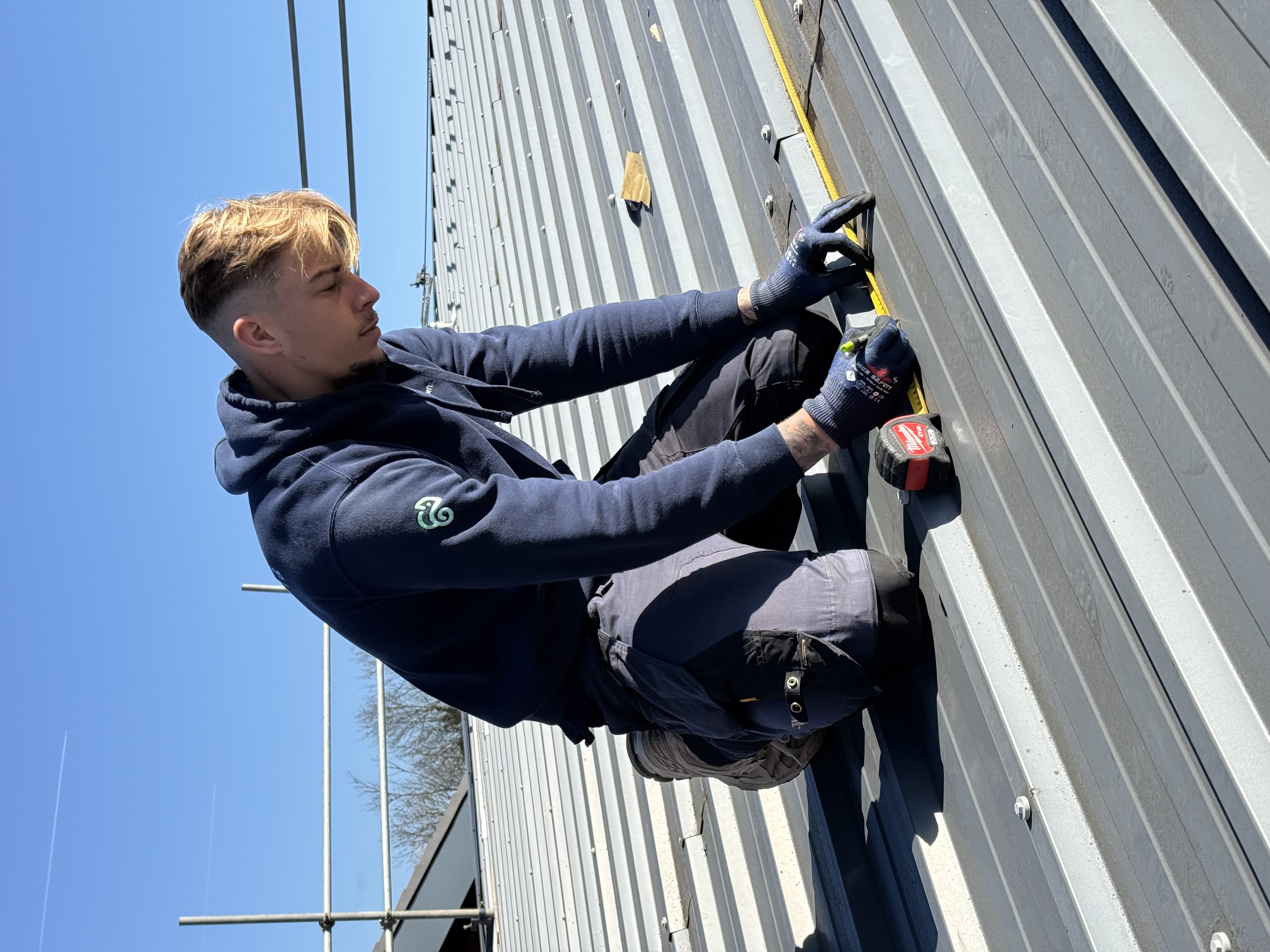 Energy Concerns installer measuring on a commercial roof