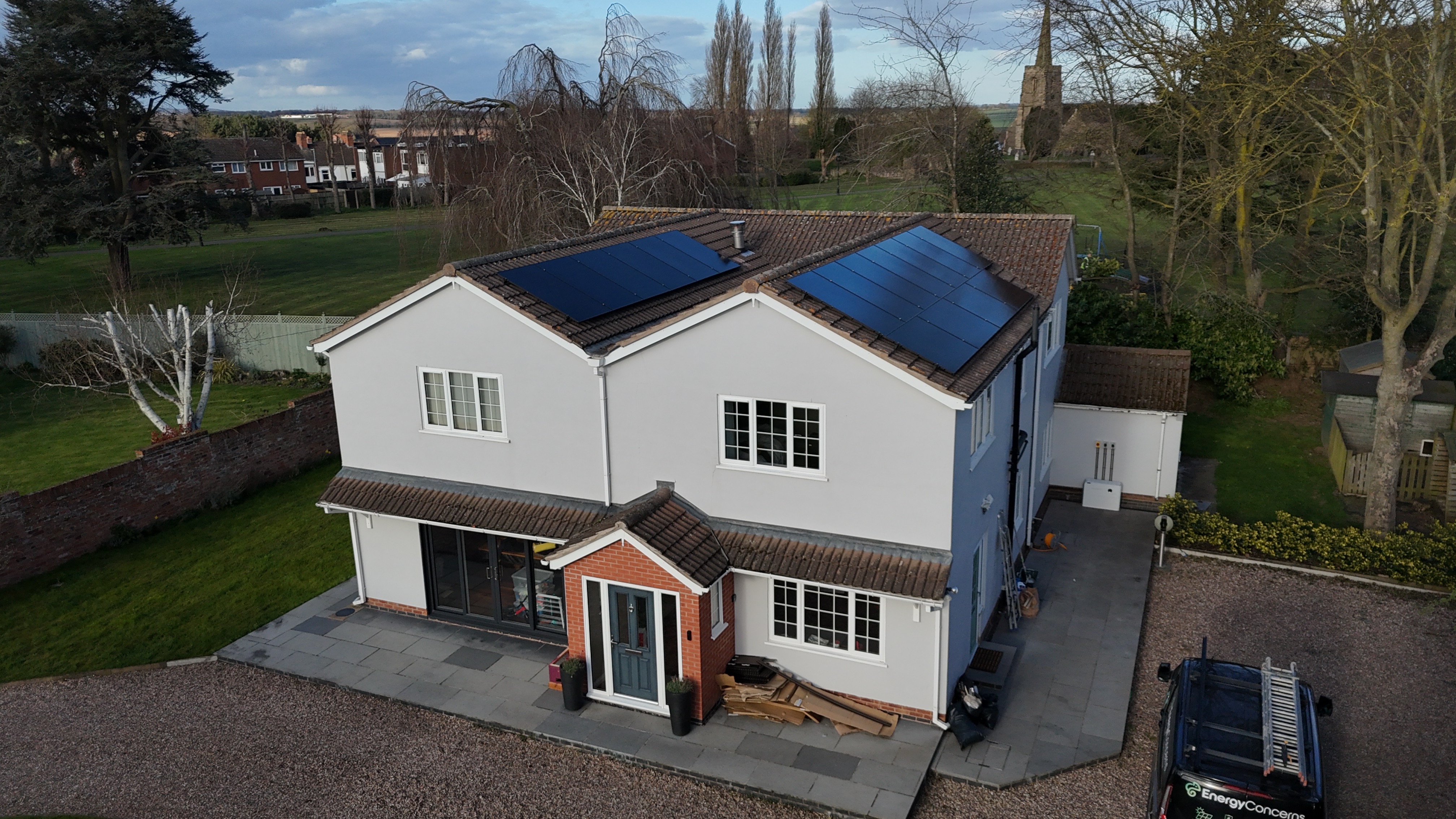 Energy Concerns solar installation on large white detached property — EC branded van on driveway